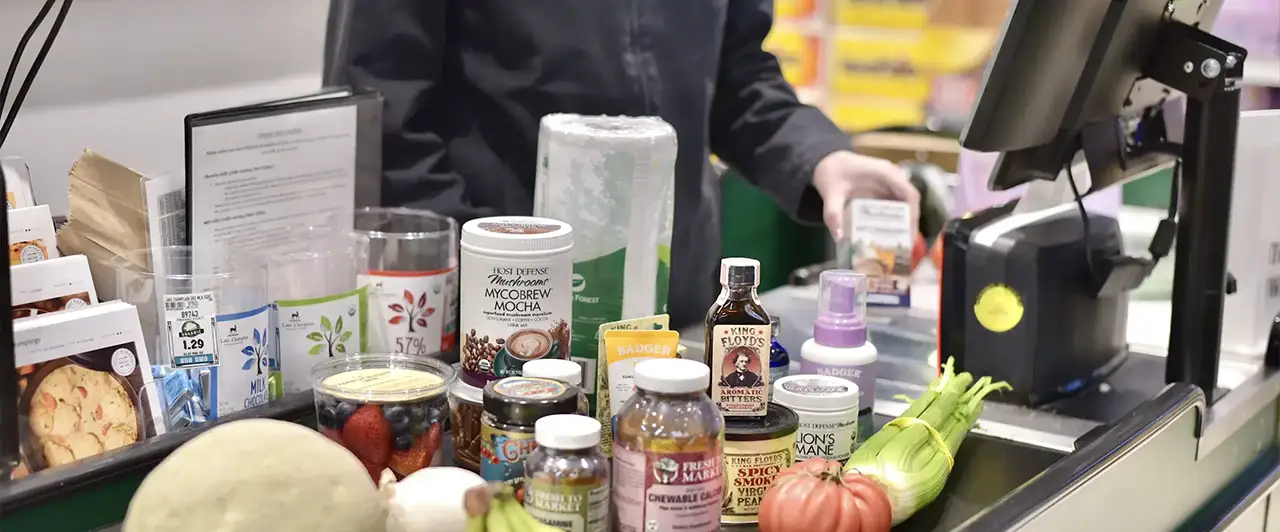 Natural health and beauty products at a grocery checkout.